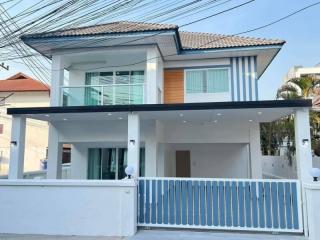 Modern two-story house with a balcony and covered parking area