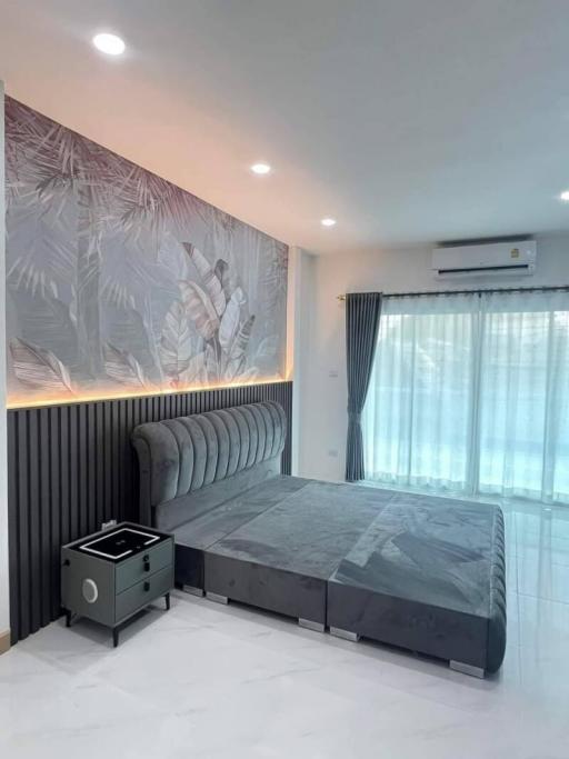 Modern bedroom with large bed and tropical wallpaper design