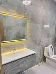 Modern bathroom with marble walls and LED mirror