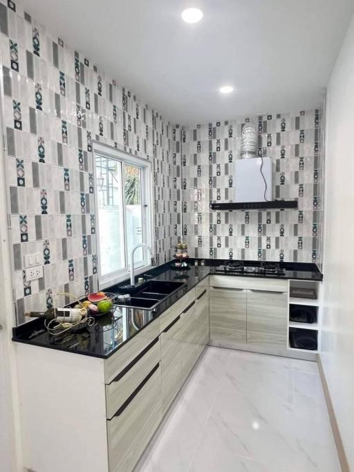 Modern kitchen with black countertops and patterned backsplash