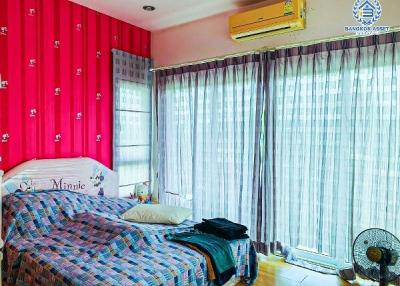 Cozy bedroom with bright pink walls and large window
