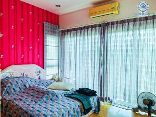 Cozy bedroom with bright pink walls and large window