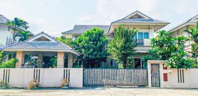 Suburban house exterior with gated fence and garden