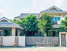 Suburban house exterior with gated fence and garden