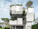 Modern multi-level residential building with lush greenery and a spacious garage entrance