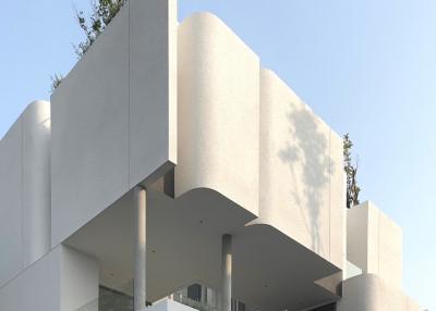 Modern architectural design of a multi-level residential building with balconies and plant decor