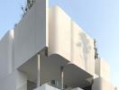 Modern architectural design of a multi-level residential building with balconies and plant decor