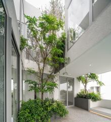 Modern building exterior with abundant greenery and glass facade