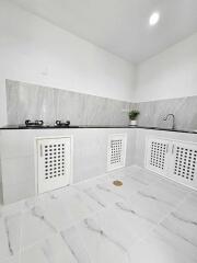 Modern kitchen with white cabinetry and marble-style tiles