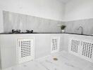 Modern kitchen with white cabinetry and marble-style tiles