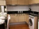 Modern kitchen with black countertops, complete with appliances and a dining area