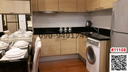 Modern kitchen with black countertops, complete with appliances and a dining area