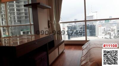 Bright bedroom with a city view through large windows