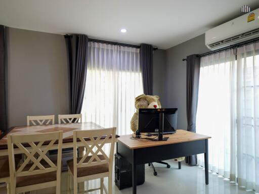 Bright home office space with a large desk, ergonomic chair, and plush toy