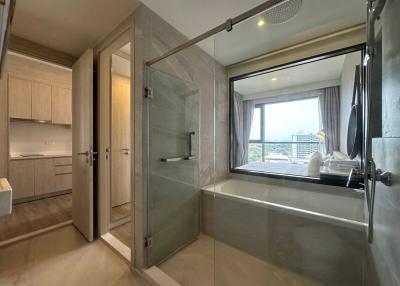 Modern bathroom with glass shower and bathtub by the window
