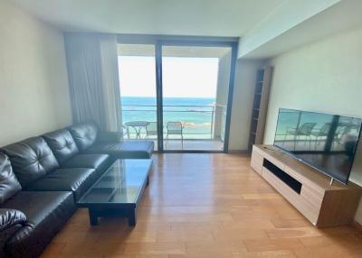 Living room with ocean view, leather sofa, and large windows