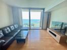 Living room with ocean view, leather sofa, and large windows