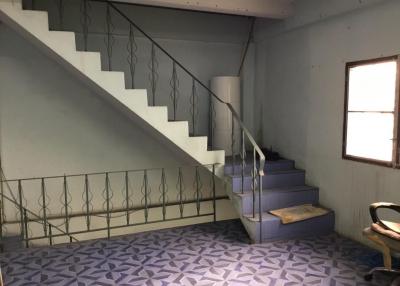 Interior view of a building with stairs, patterned flooring, and a chair