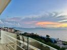 Panoramic ocean view from high-rise balcony at sunset