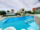 Luxury apartment complex with large swimming pool and lounge chairs