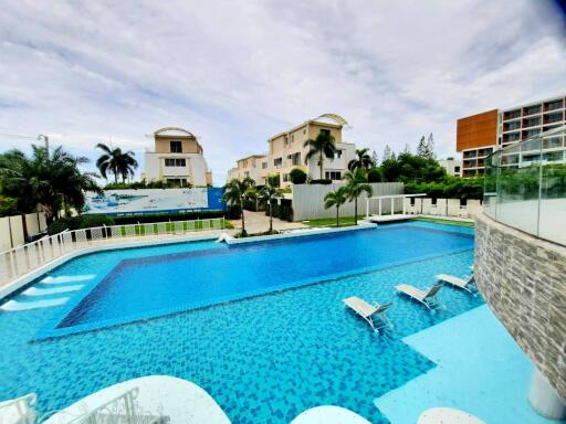 Luxury apartment complex with large swimming pool and lounge chairs