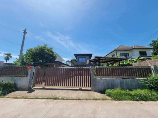 Spacious residential home exterior with blue sky and gate