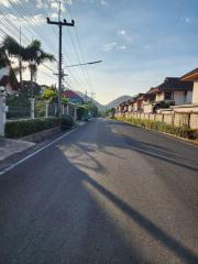 Quiet residential street with houses and clear blue sky