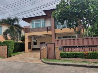 Modern two-story house with a gated driveway and landscaped front yard