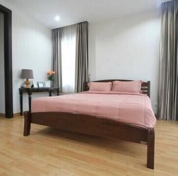 Cozy modern bedroom with a comfortable double bed and hardwood flooring