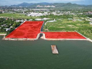 Aerial view of large waterfront area with red soil