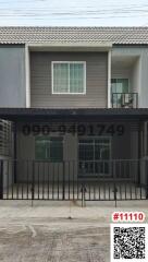 Two-story residential building with balcony and gated entrance