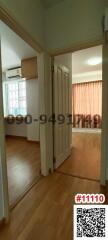 Interior view of a room entrance with wooden flooring and curtain