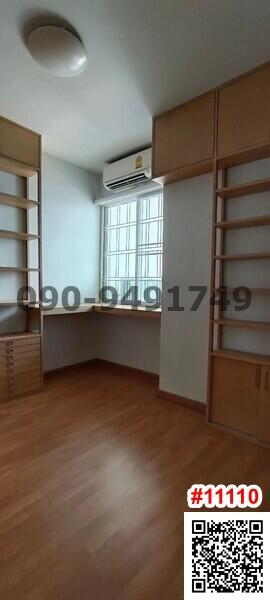 Spacious bedroom with built-in shelving units and large windows