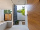 Modern house entrance with natural stone wall and wooden door