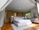 Spacious bedroom with modern design, natural light, and stylish furnishings