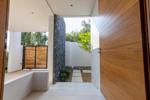 Modern home entrance with tasteful landscaping and stone accent wall