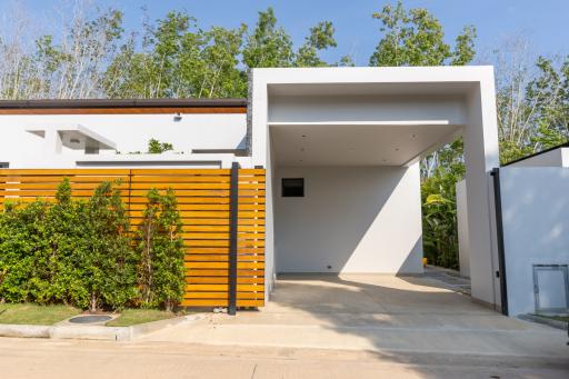 Modern home exterior with open carport and wooden slat fence