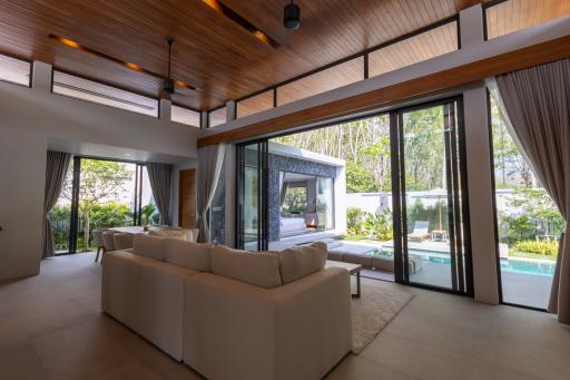 Spacious living room with high ceilings, large windows, and pool view