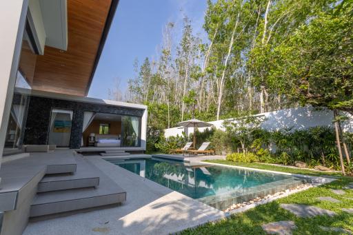 Luxurious private pool alongside modern villa with lush greenery
