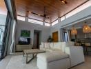 Spacious living room with high ceilings, natural light, and modern furniture