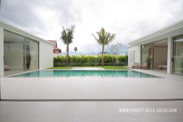 Luxurious villa with a private outdoor pool, sliding glass doors, and tropical landscaping