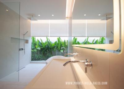 Modern bathroom with large mirror and tropical view
