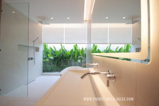Modern bathroom with large mirror and tropical view