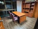 Spacious office room with large desk, chairs, and built-in shelves