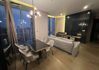 Modern living room with large windows and city view at dusk