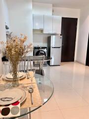 Modern kitchen with dining area including a glass table and stainless steel appliances