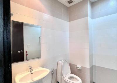 Modern bathroom with white tiles and gray flooring