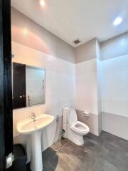 Modern bathroom with white tiles and gray flooring