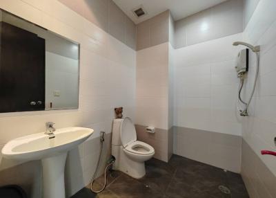 Modern white tiled bathroom with sink, toilet and shower