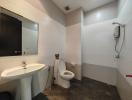 Modern white tiled bathroom with sink, toilet and shower